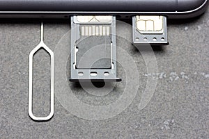 Smartphone with open SIM slots and micro SD memory on a gray background with copy space