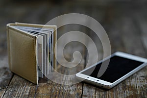 Smartphone and photo book lying on the wooden background.