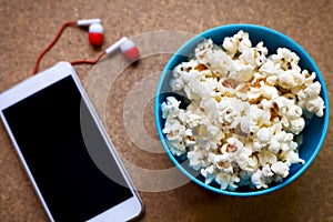 Smartphone and popcorn in bowl