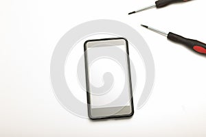 Smartphone and precision screwdrivers over white