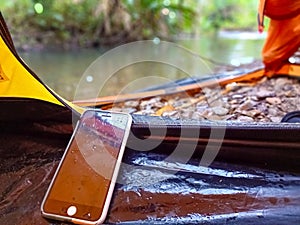 A smartphone selected focus lying in a tent on the edge of a Papuan forest river
