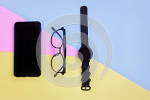 Smartphone,Smartwatch and Eyeglasses on pink,blue and yellow background