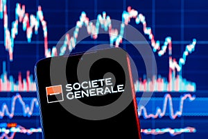 Smartphone with Societe Generale bank logo. Societe Generale stock chart on the background