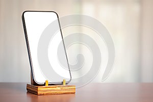 Smartphone on stand, white screen, soft light, technology and communication blend