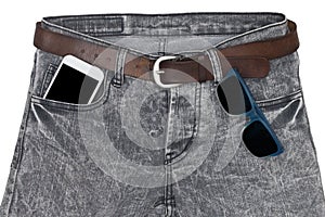 Smartphone and sunglasses in pocket jeans