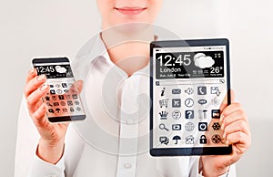 Smartphone and tablet with transparent screen in human hands.