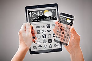 Smartphone and tablet with transparent screen in human hands.