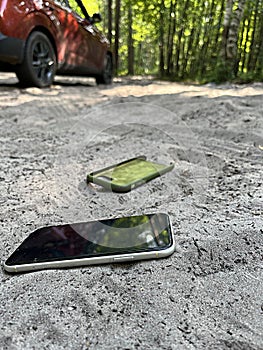 smartphone thrown out of the car lies on the road. concept of stress from information overload stress