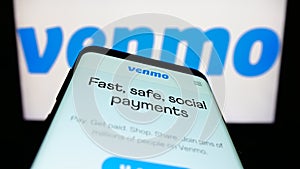 Smartphone with website of mobile payment service Venmo on screen in front of business logo.