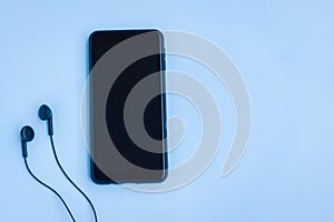 Smartphone and Wired earphones on Blue background