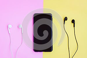 Smartphone and Wired earphones on pink and yellow background