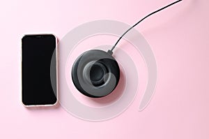 Smartphone with wireless charge on pink background