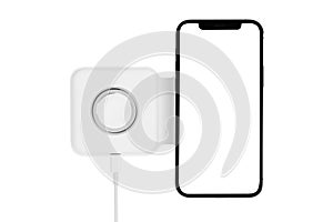 Smartphone on wireless charging on a white background. Smartphone is being charged on wireless charging close-up
