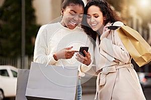 Smartphone, women and paper bag happy for shopping, sale and retail together outdoor by mall. People, product and