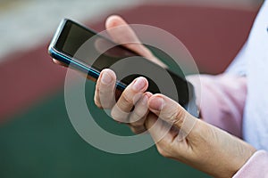 Smartphone in women`s hands close-up. Using the phone, fingers on the touch screen of the gadget. Text messages, doing business, I