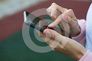 Smartphone in women`s hands close-up. Using the phone, fingers on the touch screen of the gadget. Text messages, doing business, I