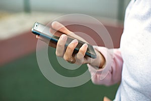 Smartphone in women`s hands close-up. Using the phone, fingers on the touch screen of the gadget. Text messages, doing business, I