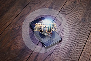 Smartphone on a wooden table. Gold inscription Sports Betting. Bets, sports betting, bookmaker. Mixed media