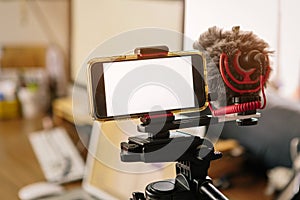 Smartphones connected to an external microphone and coupled to a tripod. Youtuber