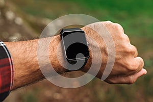 Smartwatch on male hiker hand, blank mock up screen