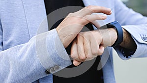 Smartwatch. Smartwatch on a business man's hand outdoor. Man's hand touching a smart watch. Closeup shot of