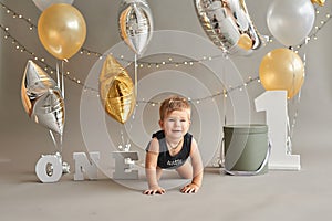 Smash cake party. Little cheerful birthday boy with first cake. Happy infant baby celebrating his first birthday. Decoration and