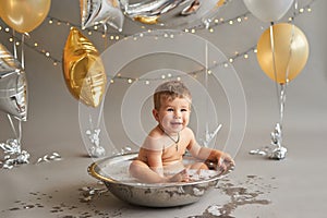 Smash cake party. Little cheerful birthday boy with first cake. Happy infant baby celebrating his first birthday. Decoration and