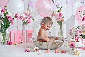 Smash cake party. Little cheerful birthday girl with first cake. Happy infant baby celebrating his first birthday. Decoration and