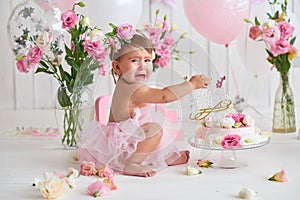 Smash cake party. Little cheerful birthday girl with first cake. Happy infant baby celebrating his first birthday. Decoration and