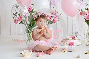 Smash cake party. Little cheerful birthday girl with first cake. Happy infant baby celebrating his first birthday. Decoration and