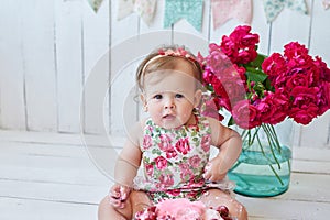 Smash cake party. Little cheerful birthday girl with first cake. Happy infant baby celebrating his first birthday. Decoration and