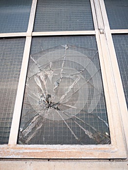 smashed broken window up close criminal damage vandalism crime