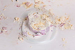 Smashed cake on white table for first birthday. Messy pieces