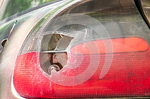 Smashed and damaged rear stop light on the car, broken by vandals or in crash accident close up