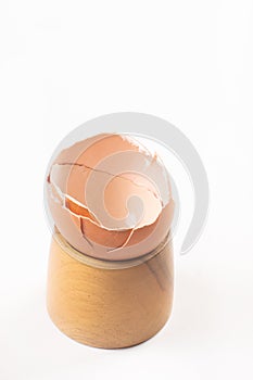 Smashed Egg Shell on the wooden egg holder isolated above white background