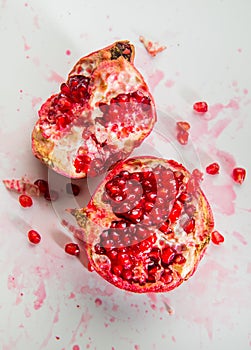 Smashed opened juicy pomegranate fruit on white background.
