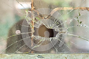 Smashed window pane with a hole in the middle