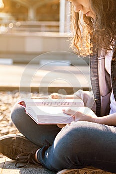 Smb illuminated by the sun reading a book in a big city