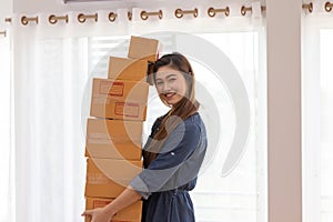 SME entrepreneur Young Asian women lifting packaging order for Online shopping at home