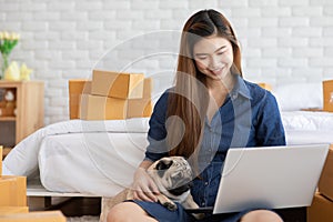 SME entrepreneur of Young women working with laptop for Online shopping at home with her dog pug breed