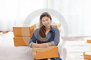 SME entrepreneur of Young women working with laptop and writing customer address for send order Online shopping at home