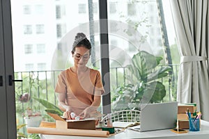 SME owner work preparing dropshipping box at the home office