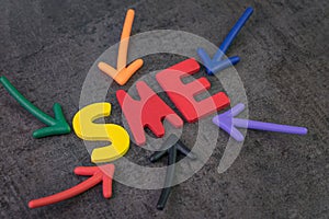 SME, small and medium-sized enterprises concept, multi color arrows pointing to the word SME at the center of black cement