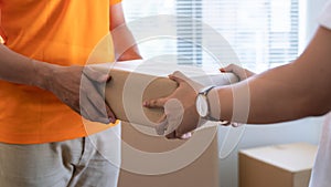 SME, Young man receives a package from the courier`s hand.