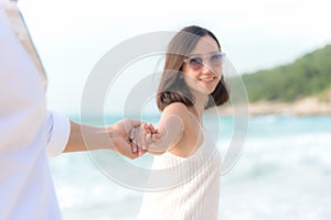 Smelling Couple summer Vacation, Asian young woman holding man hand on the beach, so happy and in love on honeymoon holiday