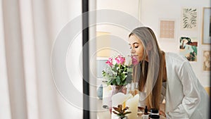 Smelling flowers, beautiful woman and beauty routine of a happy bride wearing a bathrobe while getting ready for her