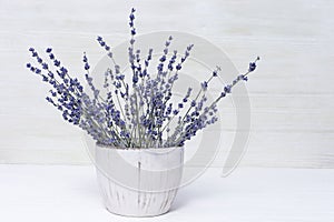 Smelling lavender flowers in pot. Bunch of natural lavender on wooden background