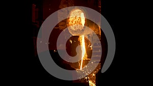Smelting works at plant. Scene. Jet of alloy is poured out and sparks are carried in different directions at smelter