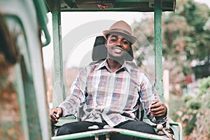 Smile african male worker operating excavator on construction site