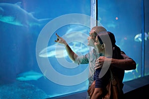 Smile, aquarium and couple pointing at fish on vacation, holiday or date together. Happiness, oceanarium and man and